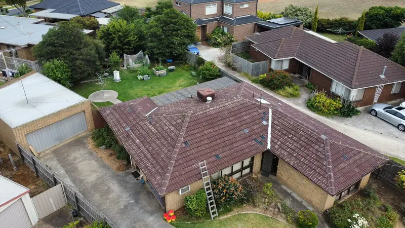 Before: a weathered brown tile roof streaked with white, seen from above