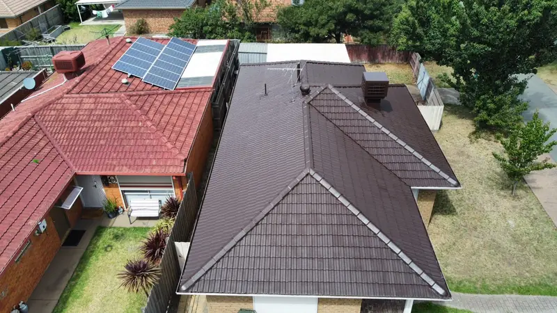 After: a dark brown tile roof, repainted, seen from above