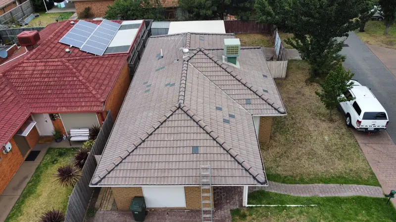 Before: a faded grey-brown tile roof with white streaks, seen from above