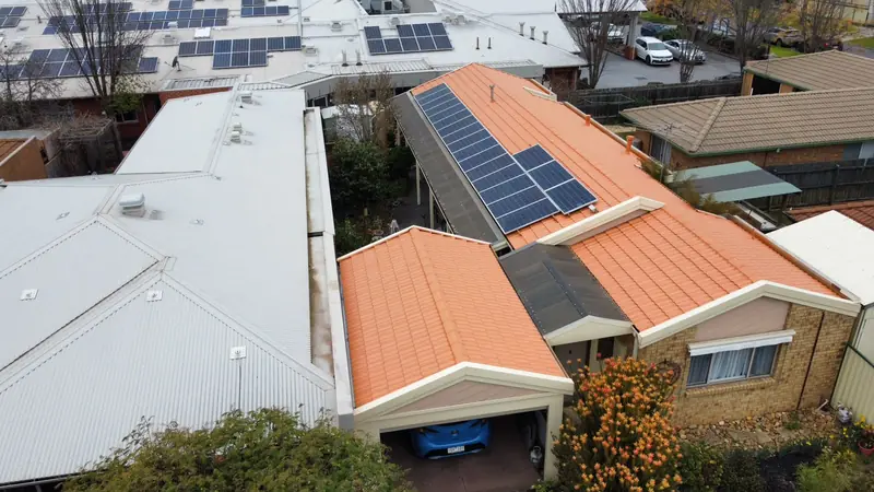 After: an orange terracotta-coloured tile roof, repainted, seen from above
