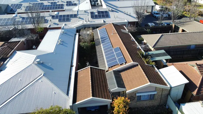 Before: a dull brown tile roof beside solar panels, seen from above
