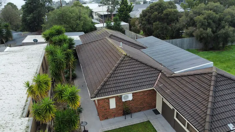 Before: a dark brown tile roof with moss along the ridges, seen from above