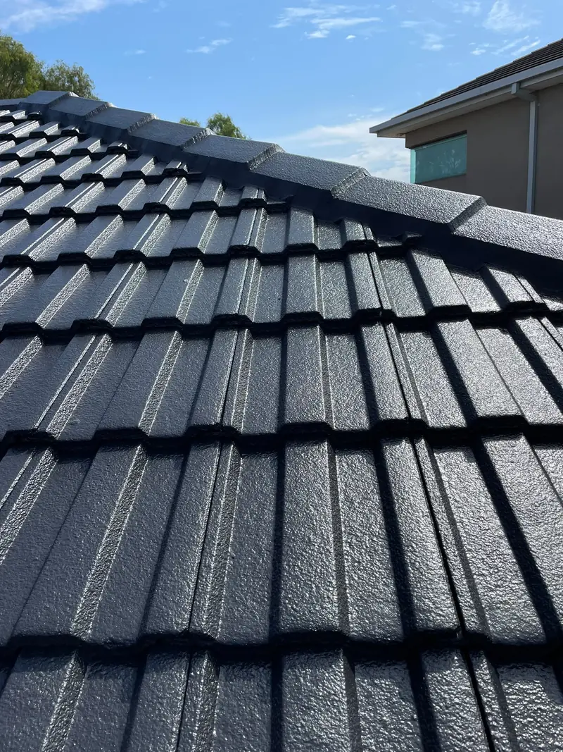 Close-up of freshly coated charcoal roof tiles and ridge caps